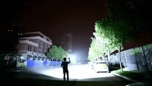 High power flashlight illuminating a dark outdoor area